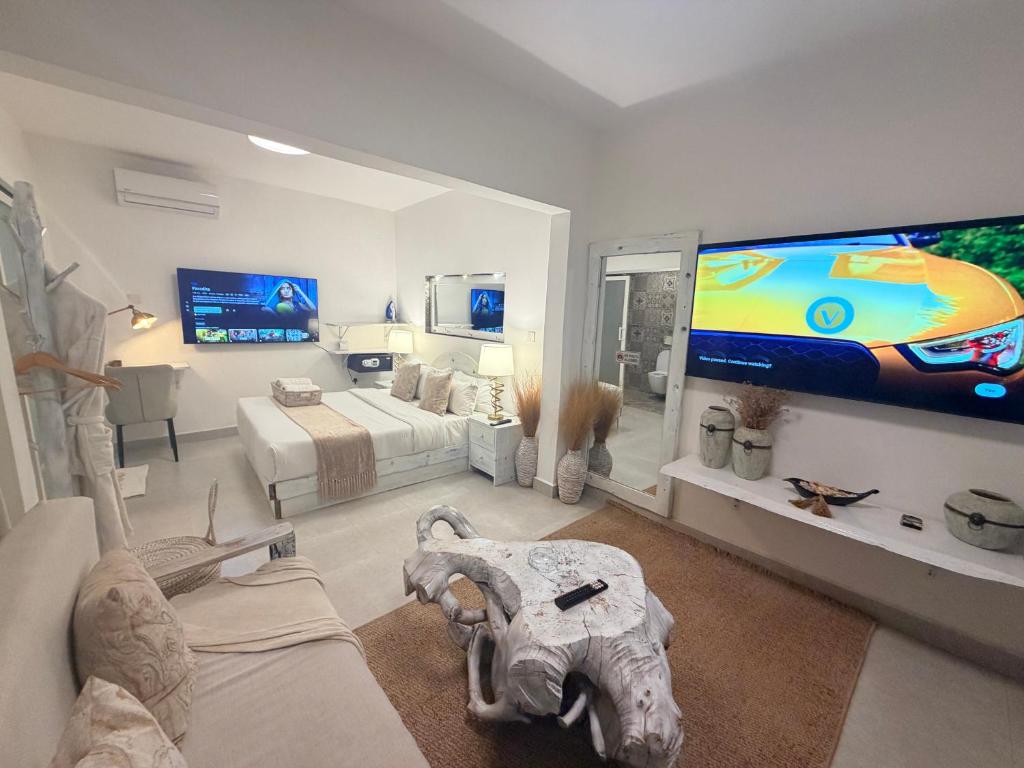 a living room with a tv and a elephant skull on the wall at Studio Crème by The Prime Escape in Arusha