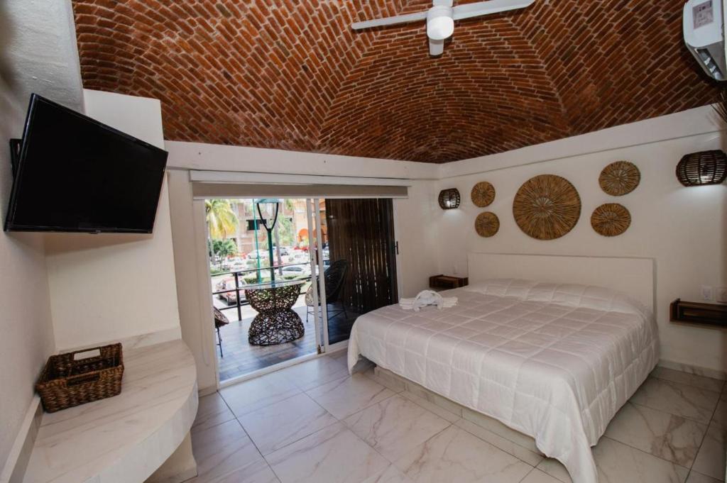 a bedroom with a bed and a flat screen tv at Paulas Suites Terraza in Ixtapa