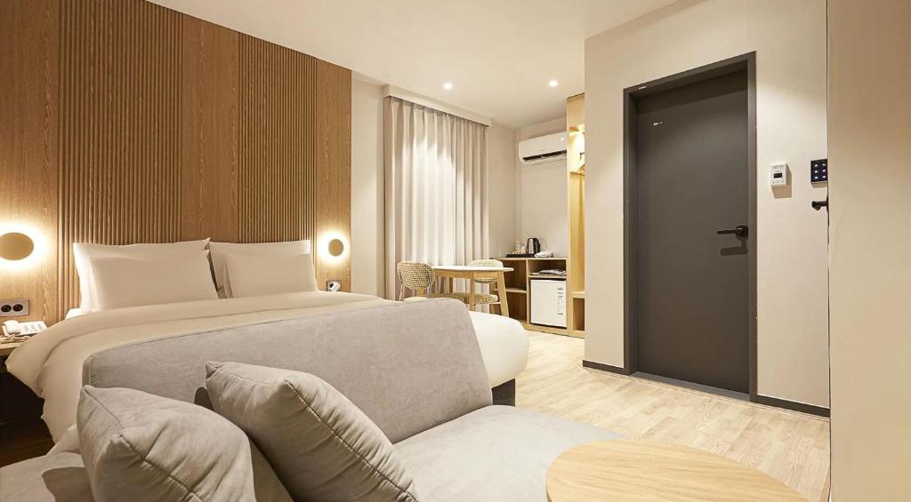 a bedroom with a bed and a couch and a chair at sotam stay hotel in Taeam