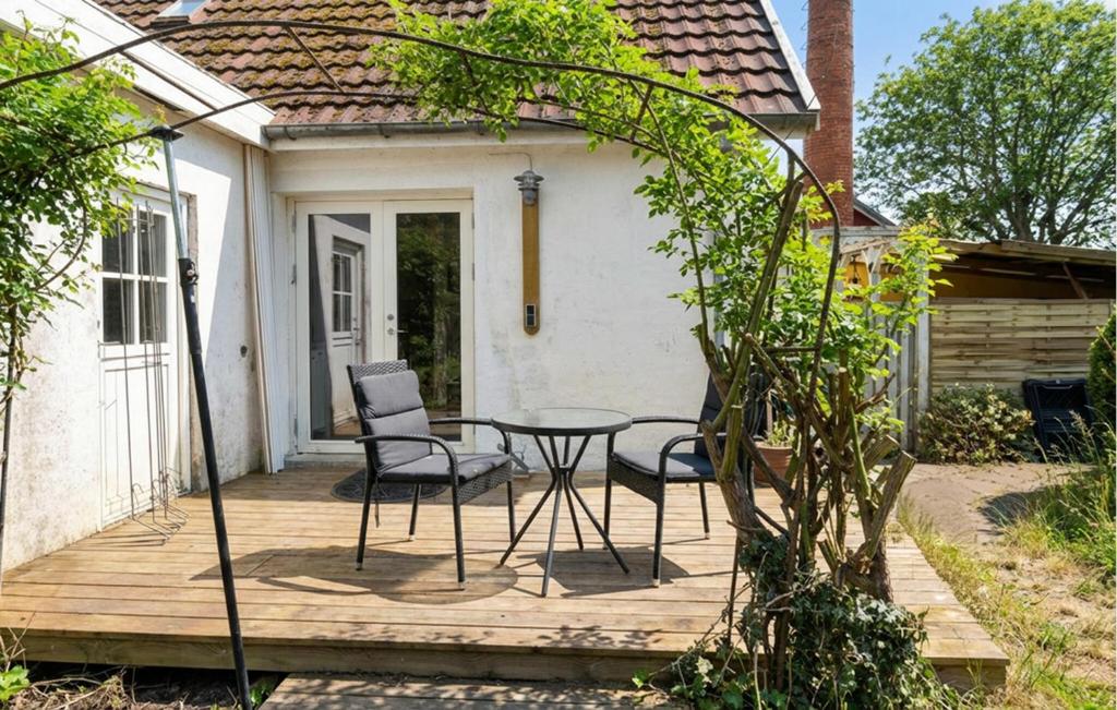 a wooden deck with a table and chairs on it at 4 Bedroom Gorgeous Home In Stege in Stege