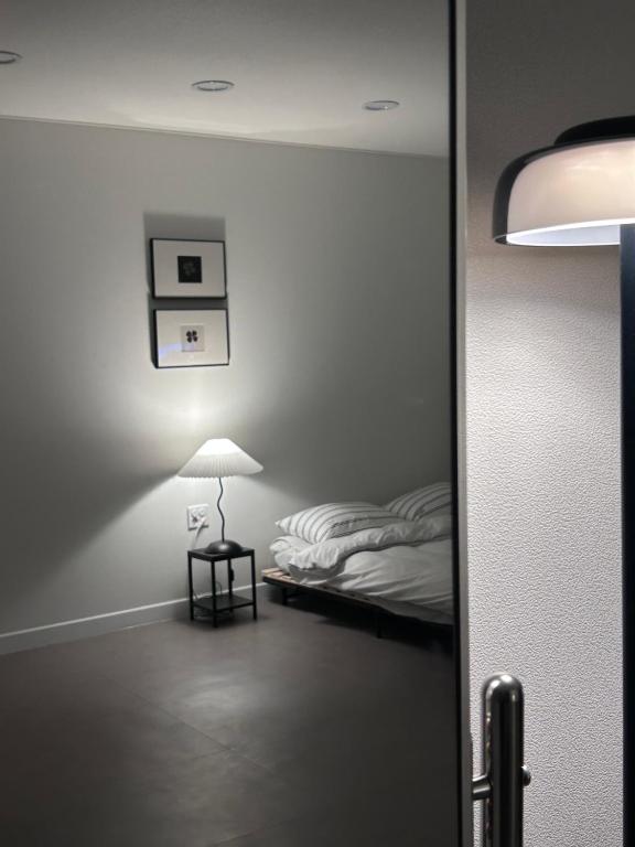 a room with a bed and a table with a lamp at momohouse 체스룸 in Chinyŏng-yŏk