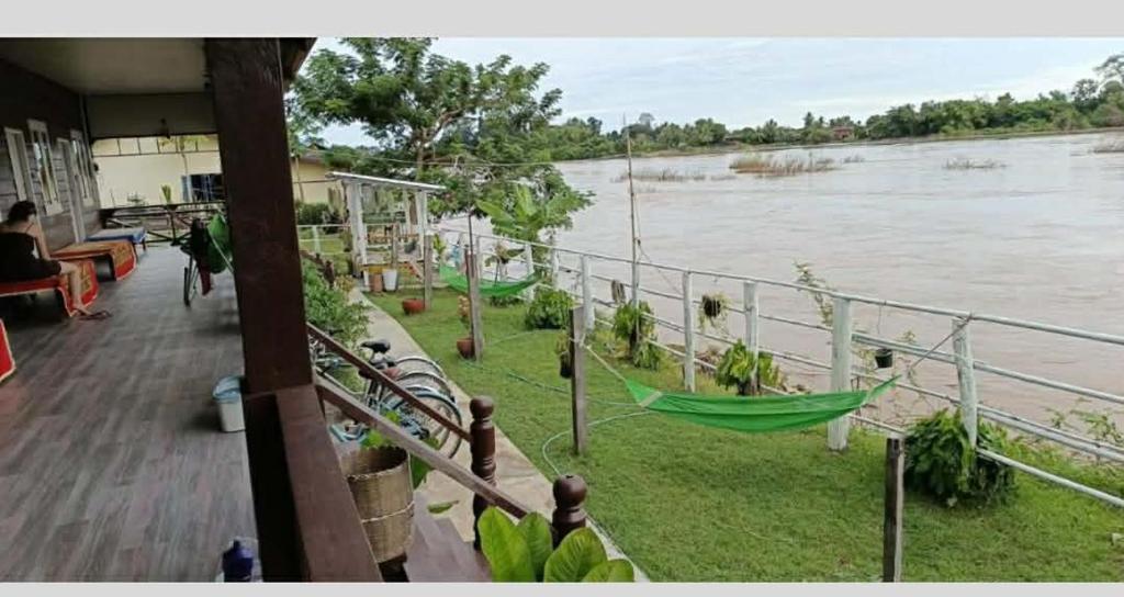 a hammock on a balcony overlooking a river at Champa resort in Don Det