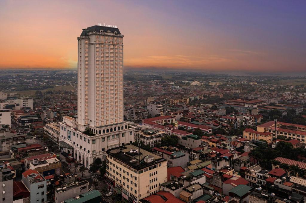 a tall building in a city at sunset at Meliá Vinpearl Phu Ly in Phủ Lý