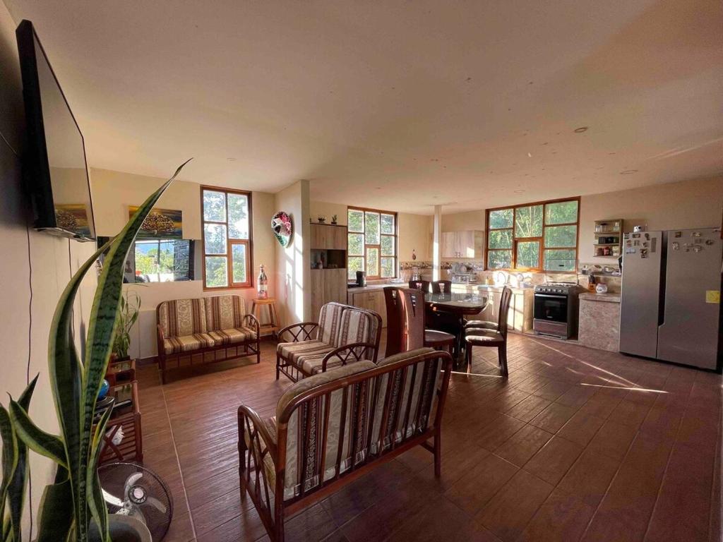 a living room with chairs and a table and a kitchen at DEPARTAMENTO ENCANTO AMAZÓNICO Macas in Macas