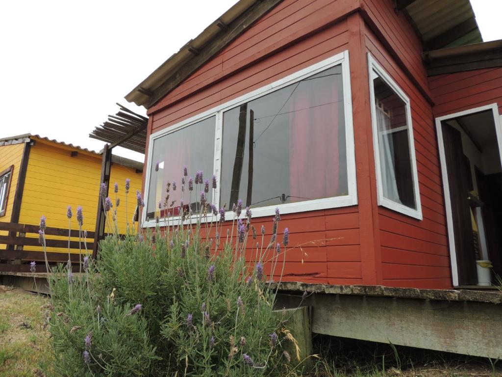 una casa roja con una ventana a un lado. en Cabañas Pietragalla, en Punta del Diablo