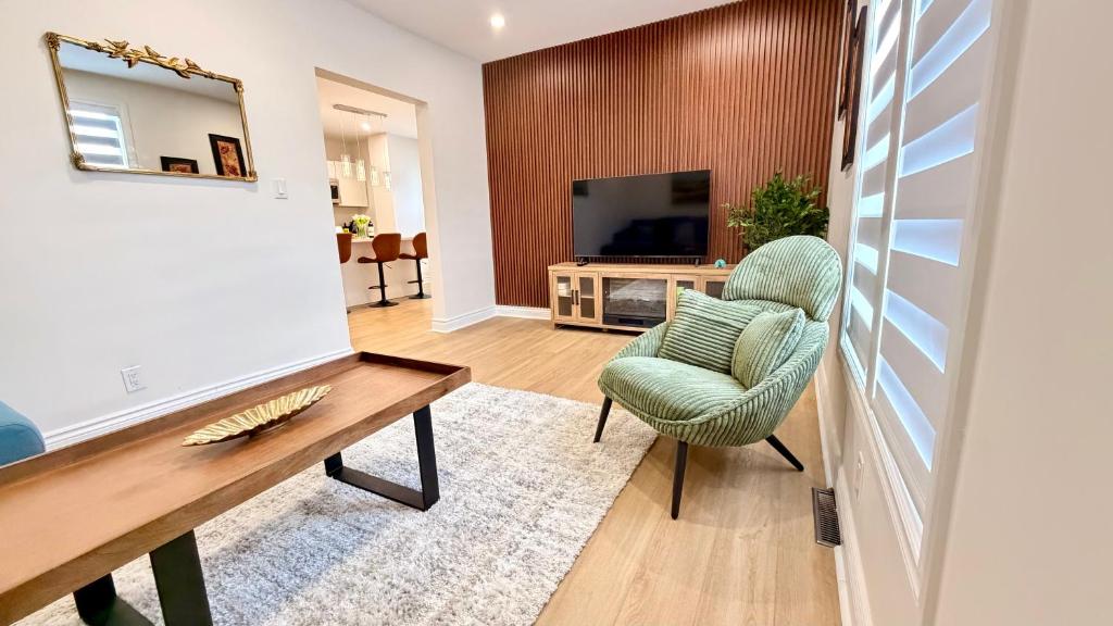 a living room with a table and a chair at Bright & Cozy Home in Niagara Falls with Free Parking in Niagara Falls