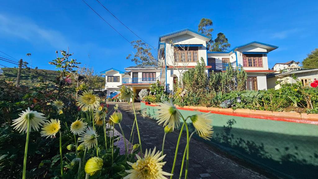 a large house with flowers in front of it at Aurora Residence Nuwara Eliya in Nuwara Eliya