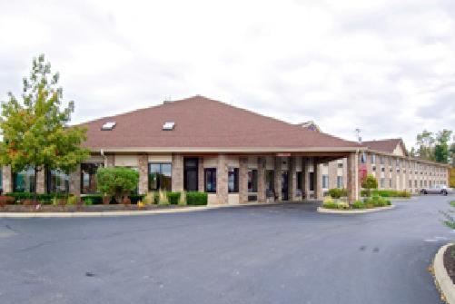 een groot gebouw met een parkeerplaats ervoor bij Baymont by Wyndham Delaware in Delaware