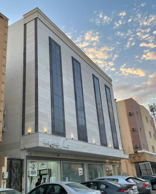 a building with cars parked in front of it at شقق نور الفخامه المخدومه in Buraydah
