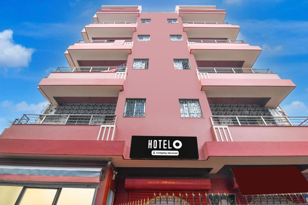 a pink building with a hotel sign on it at Super Hotel O Shalimar Railway Junction Howrah in Garden Reach