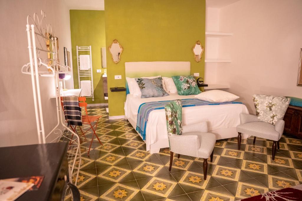 a bedroom with a bed and two chairs in it at Verde romantico in Città della Pieve