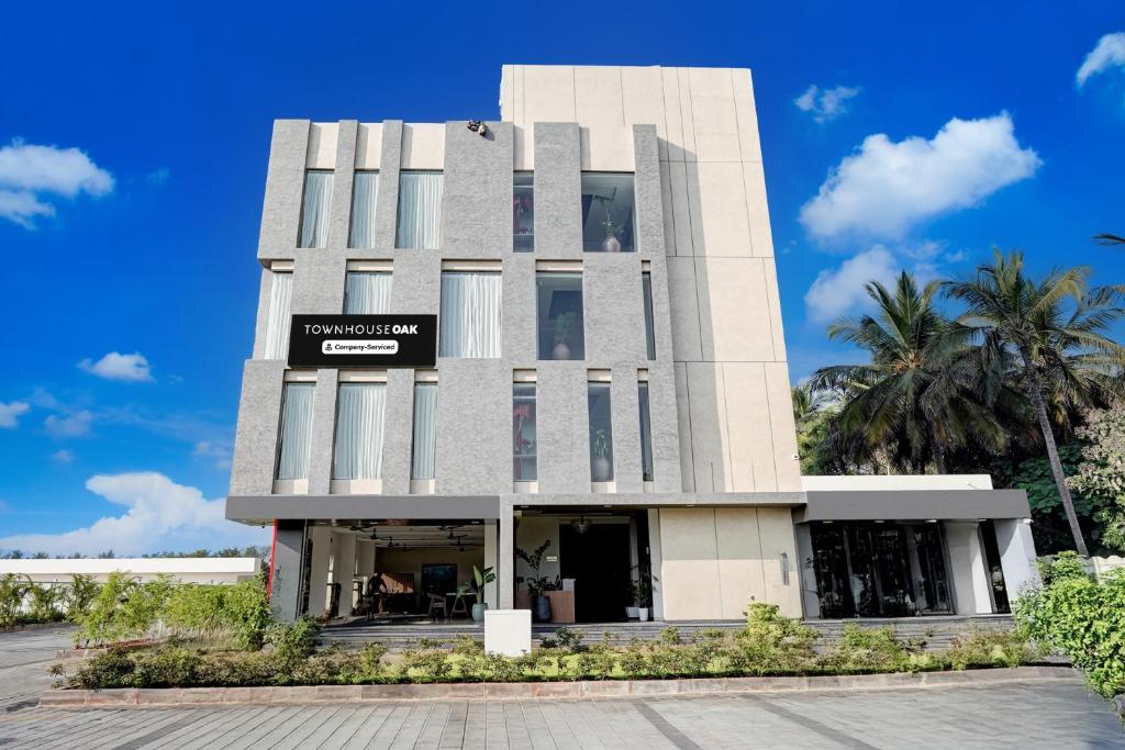 a building with a sign on the front of it at Super Townhouse Oak T. Narasipura Road Formerly Hotel Nishara in Mysore