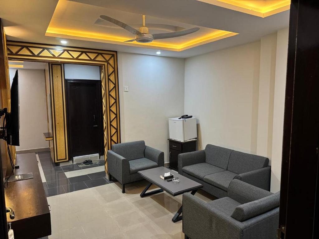 a living room with two couches and a table at Crystal Crown Hotel in Peshawar