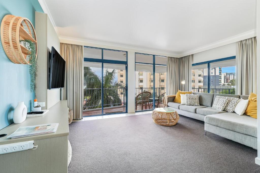a living room with a couch and a tv at Spacious Darwin Esplanade Retreat with Pool & Spa in Darwin