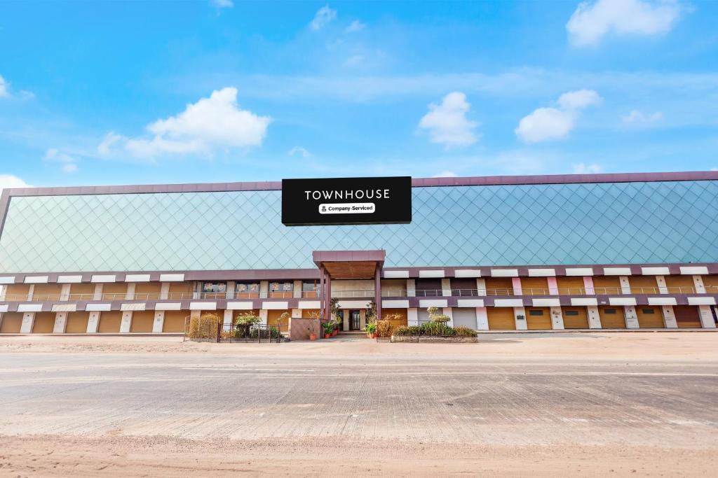 a large building with a sign on the front of it at Townhouse GIDC Ankleshwar Formerly Studio 60 in Kosamri