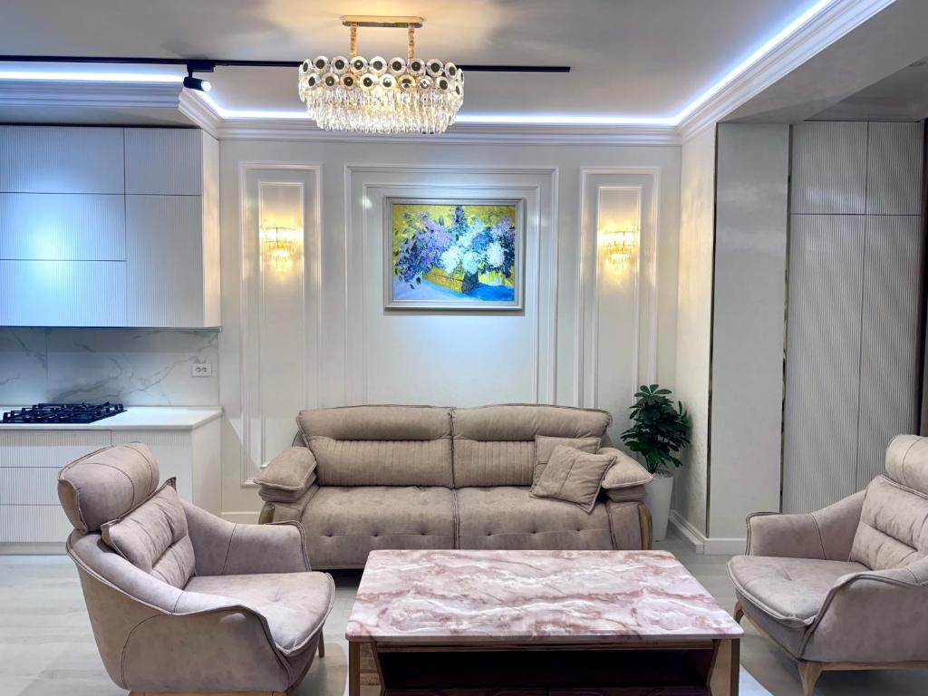 a living room with a couch and chairs and a chandelier at Boulevard in Samarkand