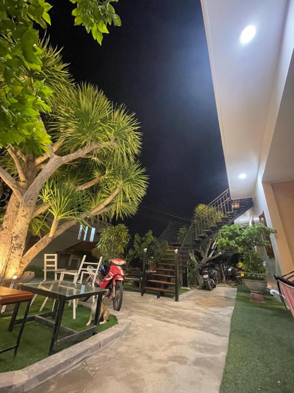 a patio with a table and a palm tree at Sun Homestay Doclet in Doc Let