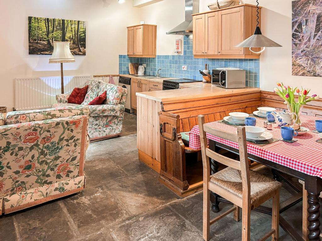 a kitchen and living room with a table and chairs at Clifford Courtyard in Kirkby Stephen