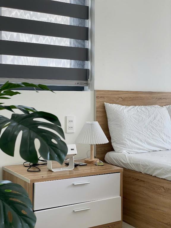 a bedroom with a bed and a nightstand with a lamp at Bắp Villa Huế in Thôn Lại Thê