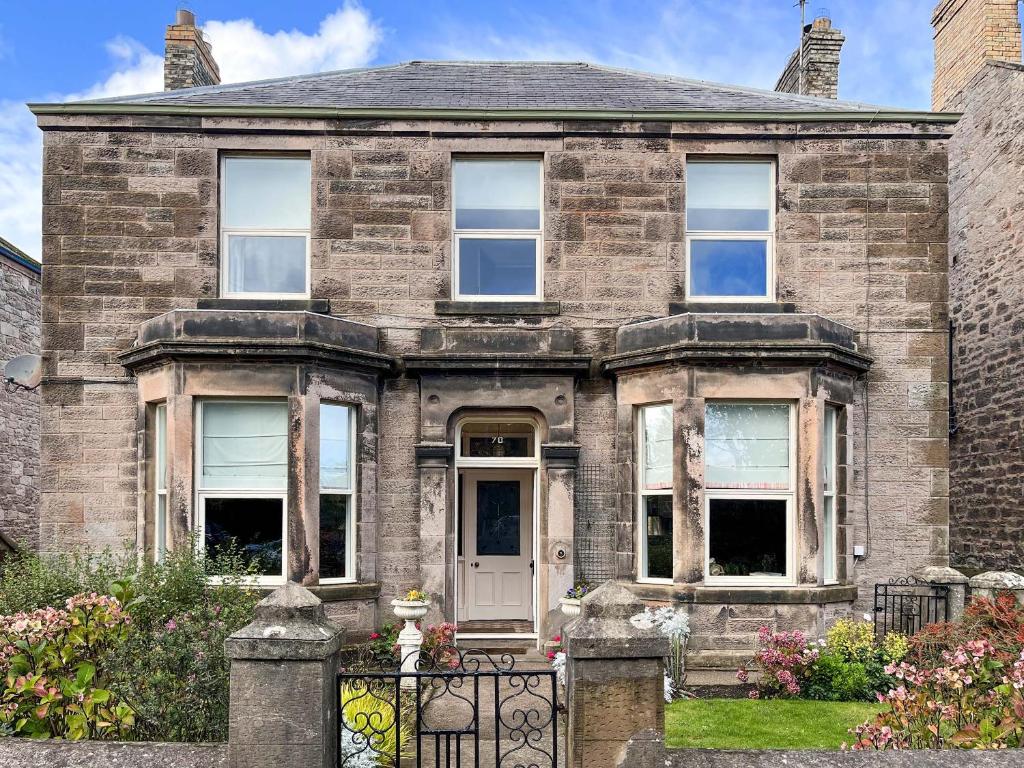 an old brick house with a gate in front of it at Embleton House - Uk51597 in Berwick-Upon-Tweed