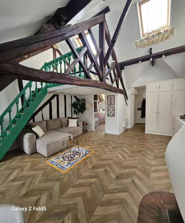 a living room with a couch and a staircase at La Cathedrale in Senlis