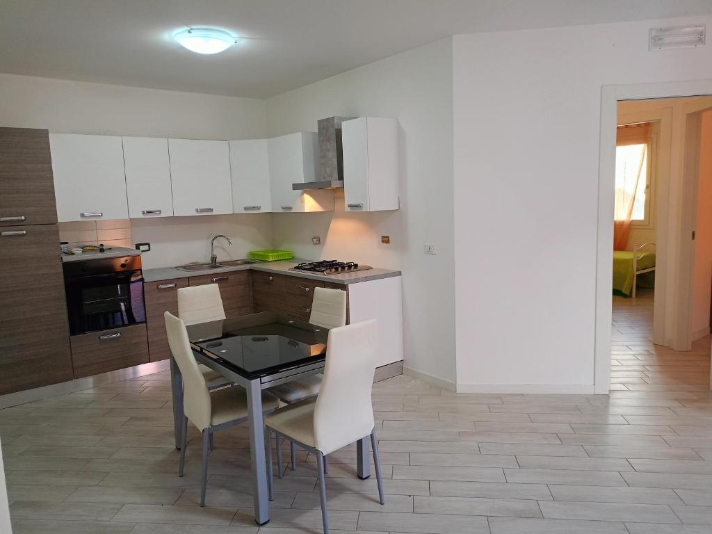 a kitchen with a table and chairs in a room at Corte DON BOSCO 5 in Monfalcone