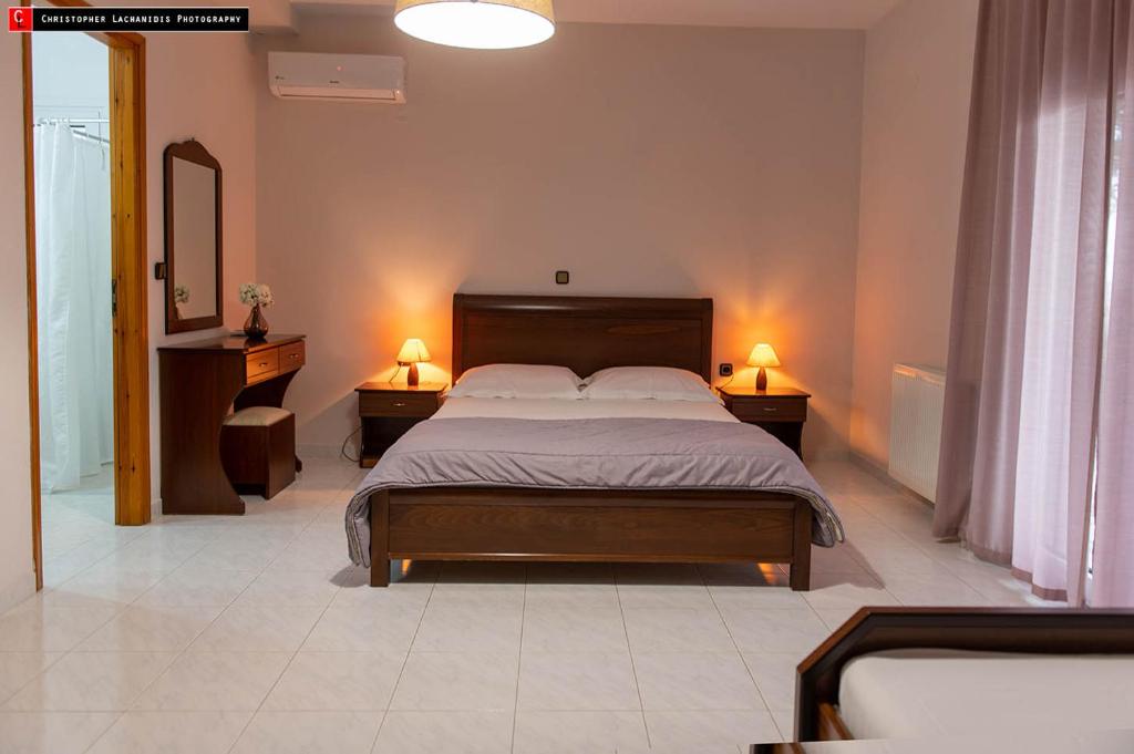a bedroom with a large bed with two night stands and a mirror at Mokos Rooms in Perdika