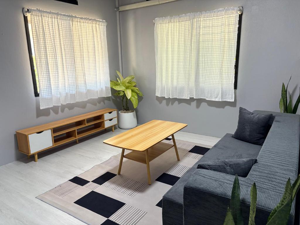 a living room with a couch and a table at Hornbills Garden in Khlaung Phai Bae
