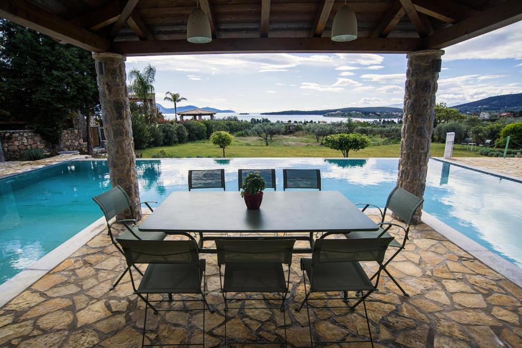 a table and chairs in front of a swimming pool at Βίλα Αοιδή in Galaxidi