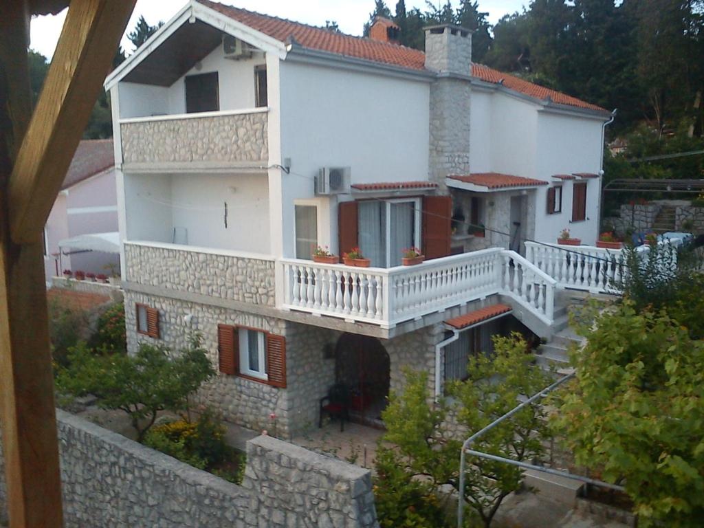 a large white house with a white balcony at Apartments in Mali Losinj 14985 in Mali Lošinj