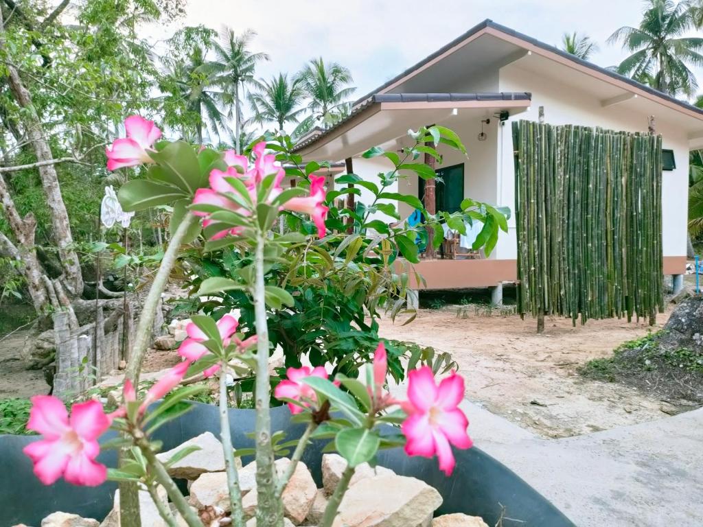 a house with pink flowers in front of it at Suanthara kokut in Ko Kood