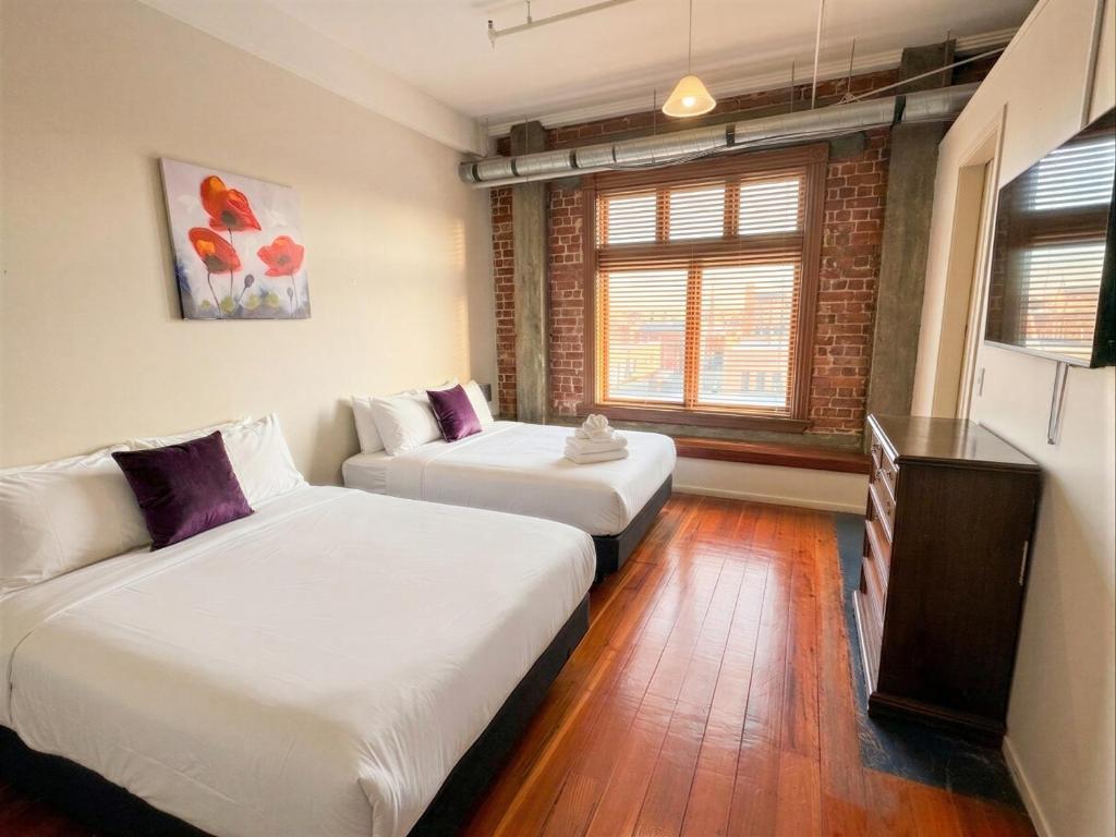 a room with two beds and a television in it at Aura Hotel in Wellington