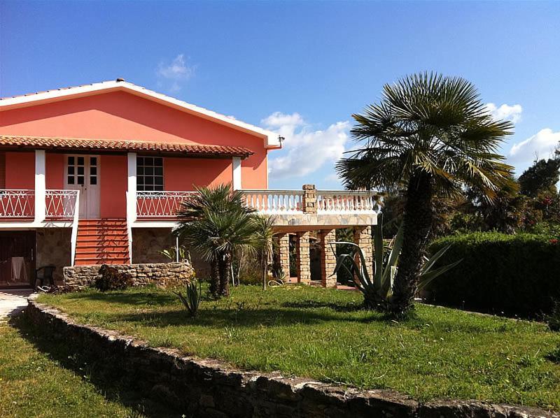 una casa con una palmera delante de ella en Agave Alghero, en Fertilia