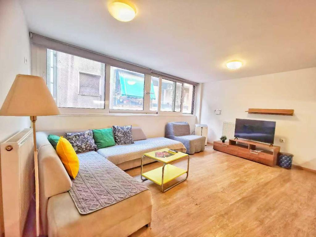 a living room with a couch and a tv at Cozy & Modern Flat for 5 in Athens in Athens