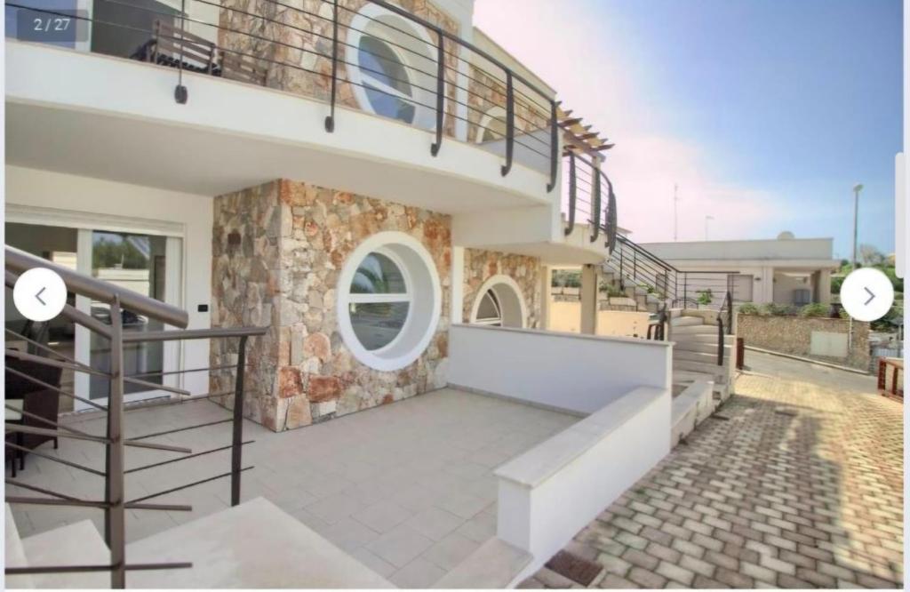 a house with a staircase and a round window at Casa Ca 'Luci in Marina San Gregorio