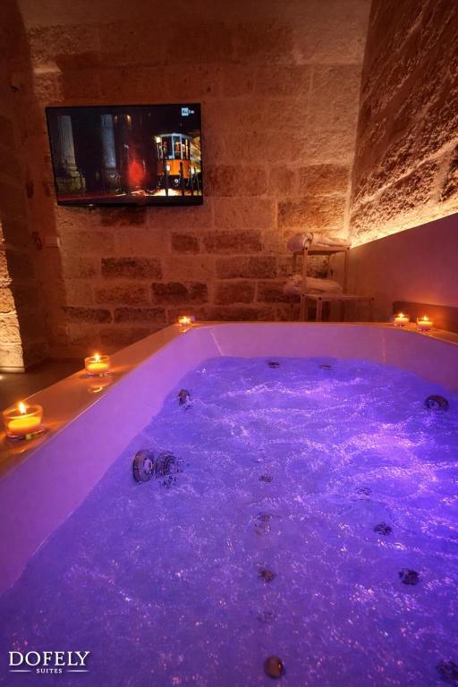 a jacuzzi tub with purple lights in a room at Dofely Suites - Tritone in Polignano a Mare