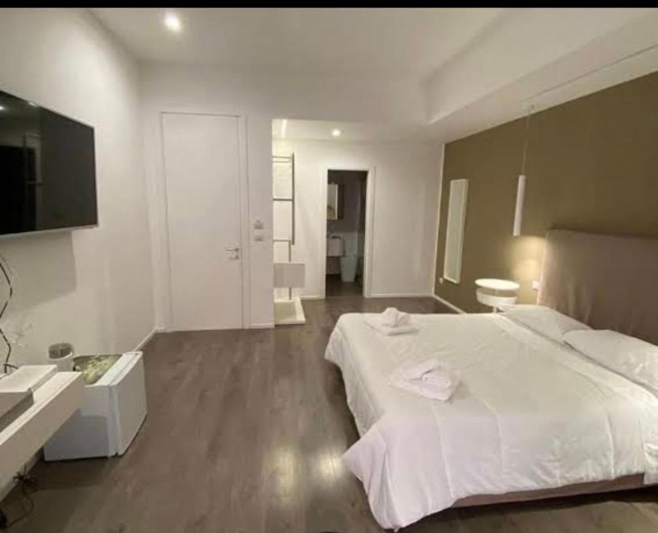 a bedroom with a large white bed and a bathroom at Primo Piano in Sparano in Bari
