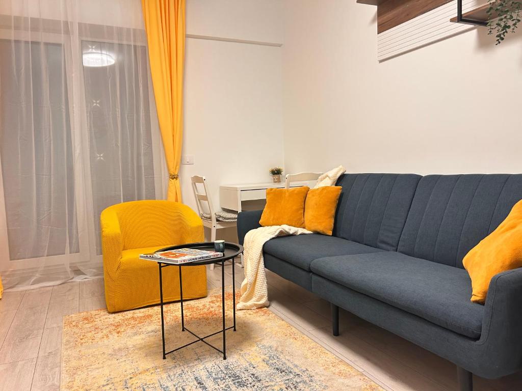 a living room with a blue couch and a yellow chair at Yellow Dawn Modern Flat in Quiet Area with Garage Parking and Self Check-In in Rediu