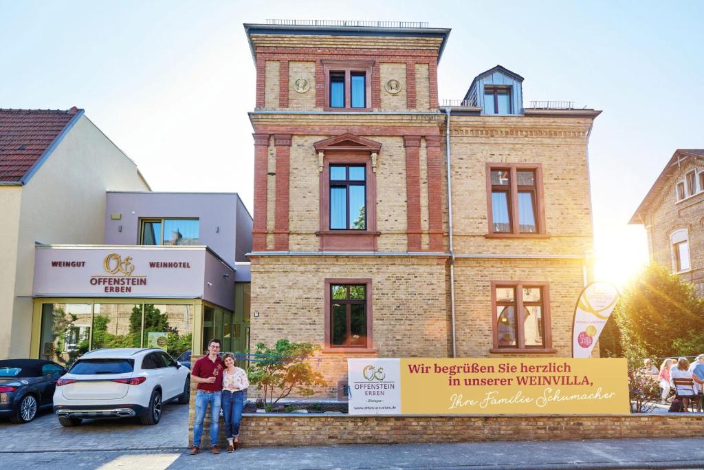 a family standing in front of a building at Weinhotel OFFENSTEIN ERBEN in Eltville