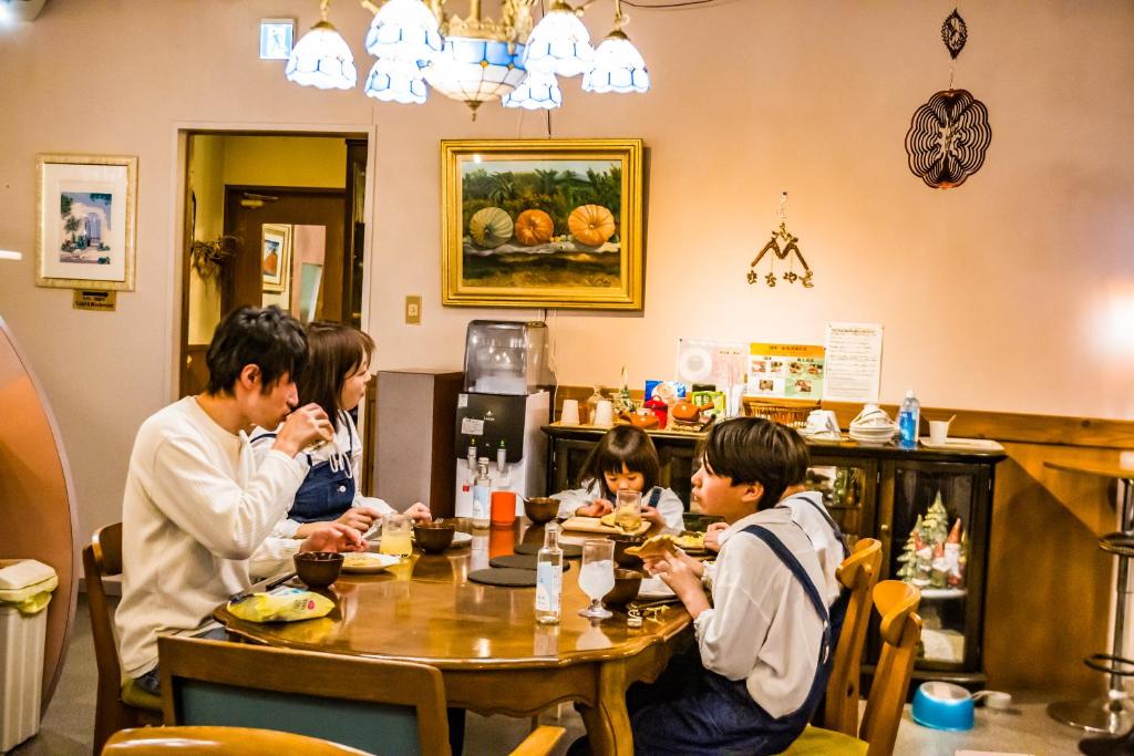 a group of people sitting at a table in a restaurant at まちやど　Motomachi in Daigo