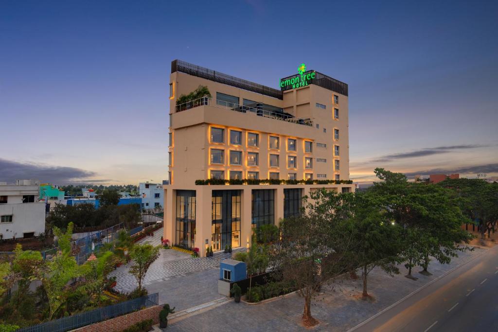 a tall building with a green sign on top of it at Lemon Tree Hotel, Bhubaneswar in Bhubaneshwar