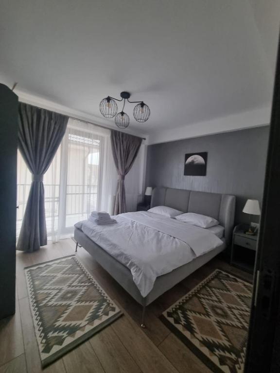 a bedroom with a bed and a large window at ApuLux Apartments in Alba Iulia