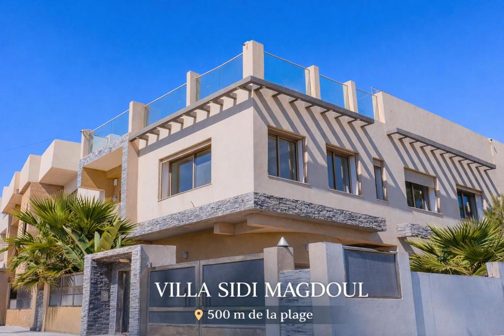 a building with a sign in front of it at Villa moderne à 5 min de la plage avec jardin et 3 salons in Essaouira
