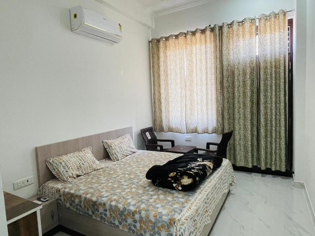 a bedroom with a bed and a window at Hotel Devansh , Niwai in Palāi