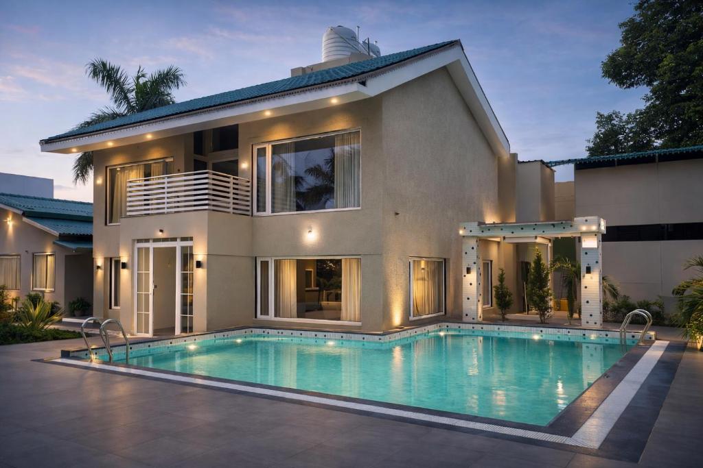 a house with a swimming pool in front of a house at Amber Resort & Spa in Indore