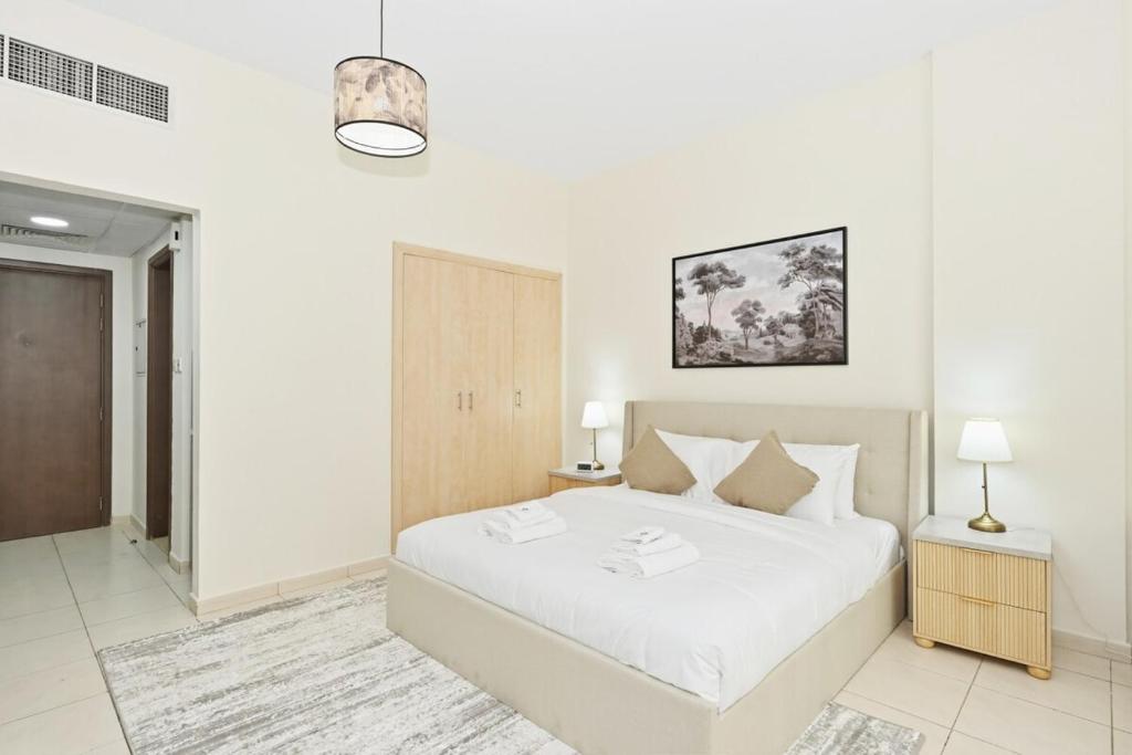 a bedroom with a large white bed in a room at Bloomfields Studio Emirates Cluster 24 Intl. City in Dubai