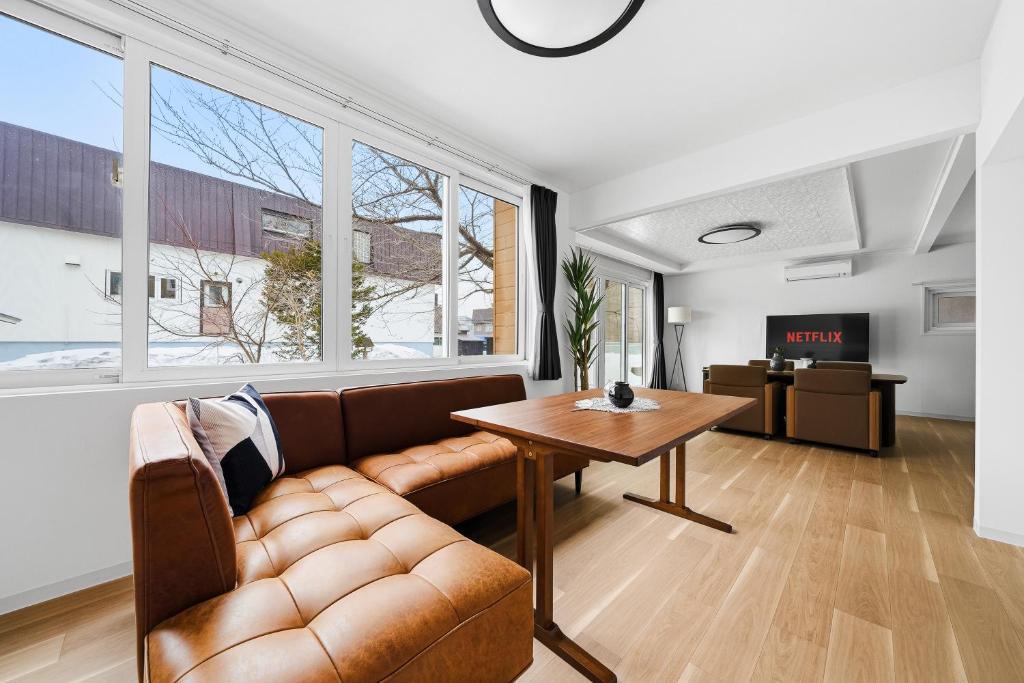 a living room with a couch and a table at Nord Birch in Tōbetsu