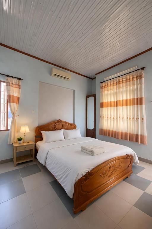 a bedroom with a large bed and a window at Hạnh Homestay in Thôn Trị Thủy