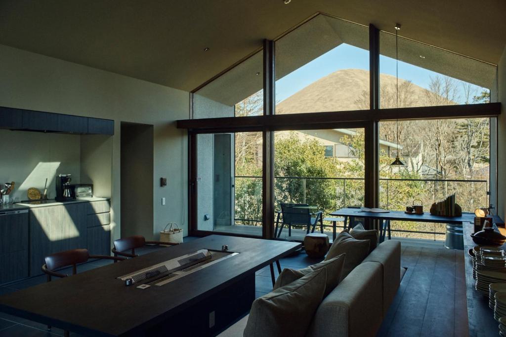 a living room with a table and a large window at Hiire IZU OMURO in Ito