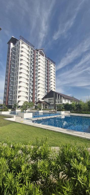 a large building with a swimming pool in front of it at The Crib at Royal Oceancrest Mactan in Lapu Lapu City